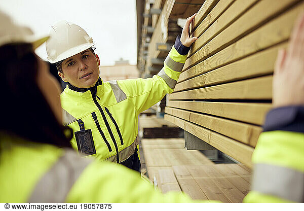 Multiracial female workers discussing over planks stacked at industry