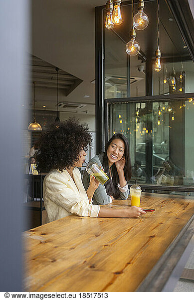 Multiracial friends sitting together at cafe