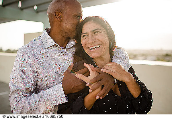 Multiracial Late Forties Couple Embracing at Sunset in San Diego