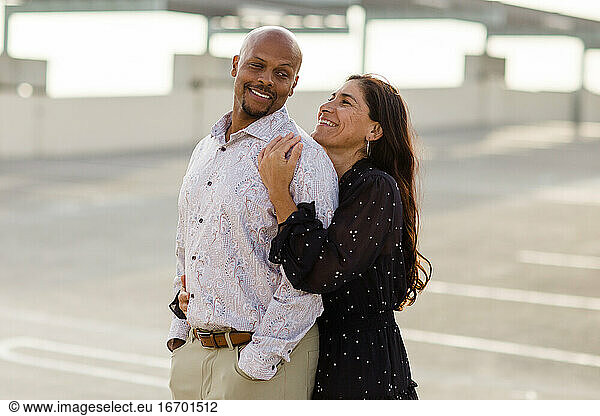 Multiracial Late Forties Couple Embracing at Sunset in San Diego