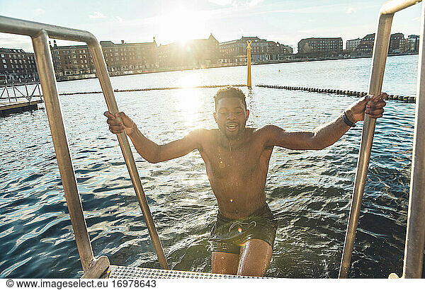Multiracial Millennial Climbing Out After Cold Swim in South Denmark
