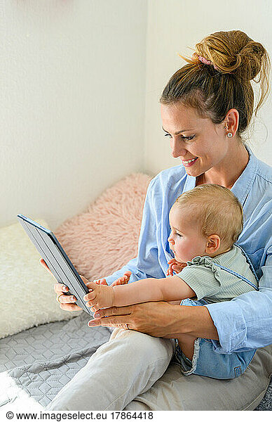 mum and child looking digital tablet at home