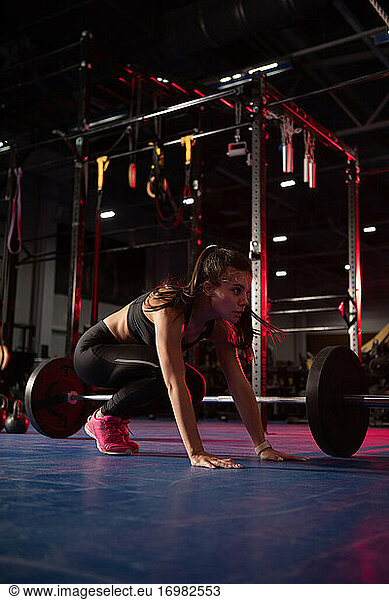 Muscular sportswoman doing squat thrust exercise Muscular sportswoman