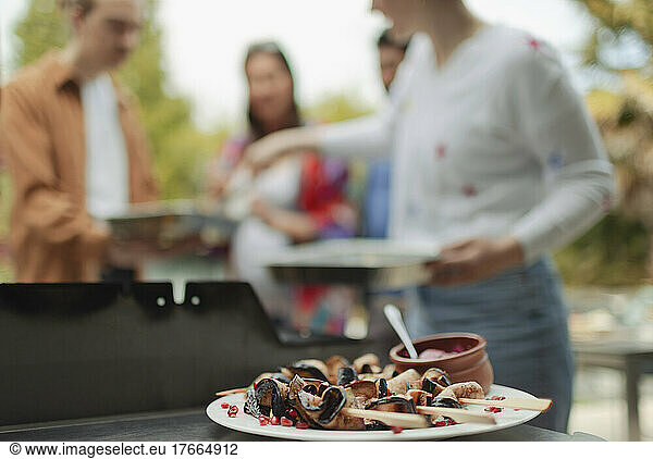 Mushroom skewers on plate next to barbecue grill