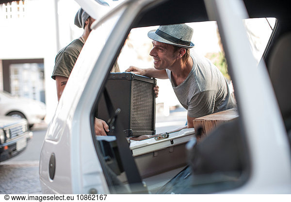 Musiker packen Ausrüstung in ein Fahrzeug