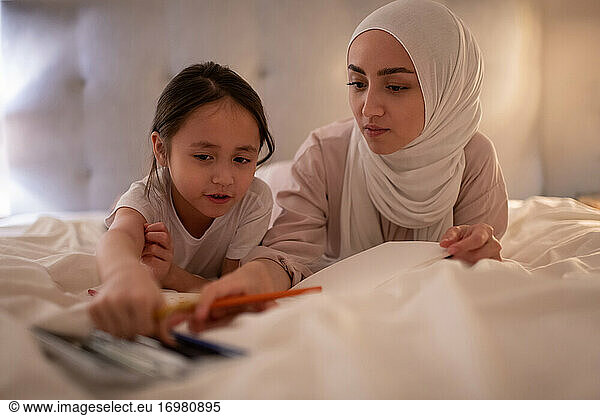 Muslim mother and daughter choosing pencils