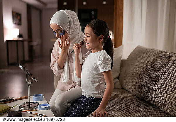 Muslimische Mutter und Tochter beim Schminken