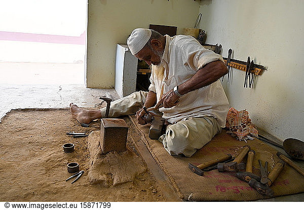 Muslimischer Glockenmacher  der Kupfer in Form schlägt  um von Hand Glocken für das Vieh oder für das Haus herzustellen  Dorf Nirona  Gujarat  Indien  Asien