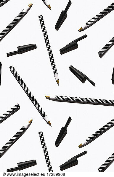 Muster aus schwarz-weiß gestreiften Stiften  flach auf weißem Hintergrund