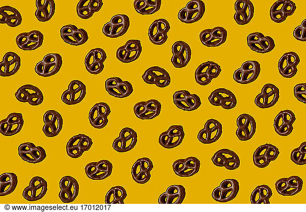 Muster von Schokoladenbrezeln auf gelbem Hintergrund