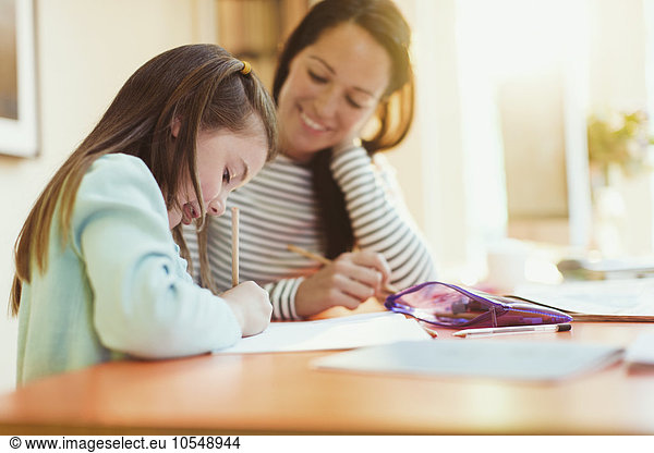Mutter beobachtet Tochter machen Hausaufgaben