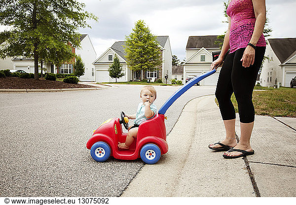 Mutter schiebt Sohn in Spielzeugauto