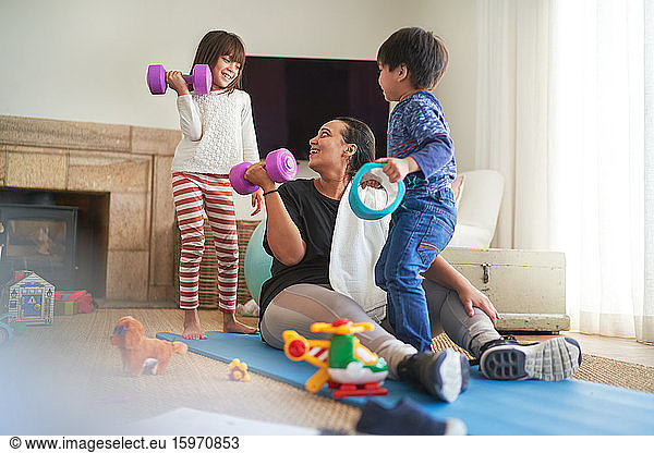 Mutter und Kinder beim Sport im Wohnzimmer