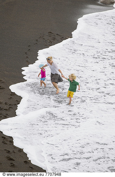 Mutter und Kinder beim Wellenreiten