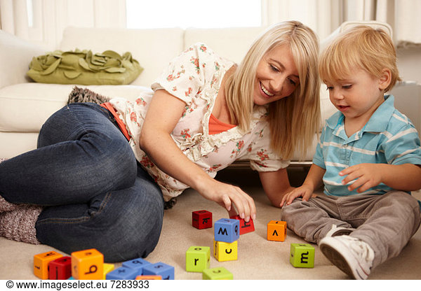Mutter und Sohn spielen mit Alphabetblöcken