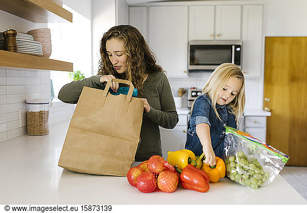 Mutter und Tochter beim Auspacken von Lebensmitteln