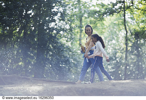 Mutter und Tochter beim Händchenhalten beim Wandern im Sommerwald