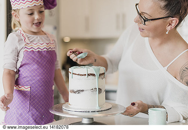 Mutter und Tochter dekorieren Kuchen