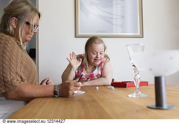 Mutter und Tochter mit Down-Syndrom spielen ein Spiel