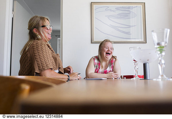 Mutter und Tochter mit Down-Syndrom spielen ein Spiel