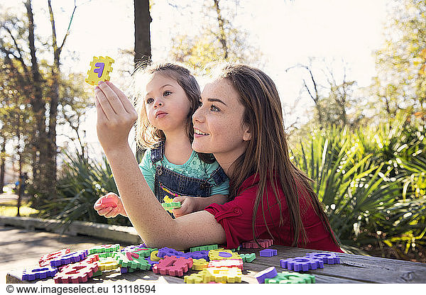 Mutter unterrichtet Tochter im Park Alphabete