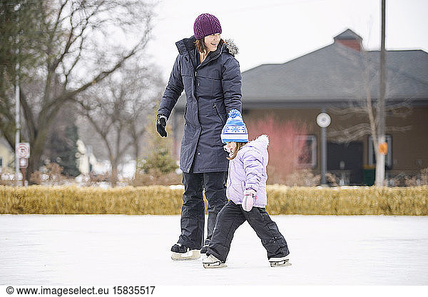 Mutter unterrichtet Tochter zum Schlittschuhlaufen