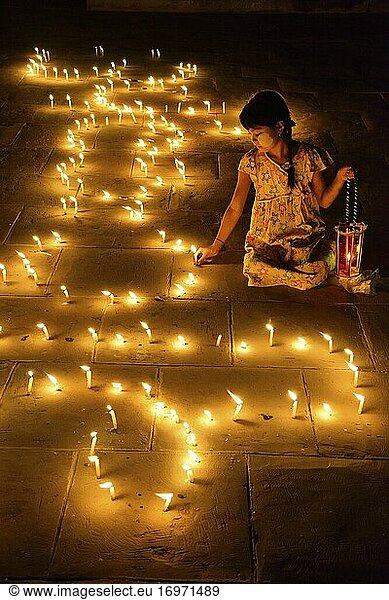 Myanmar  Bagan  Ananda-Tempel  Thadingyut-Lichterfest  Junges Mädchen zündet Kerzen an.