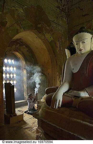 Myanmar  Bagan  Minnanthu  Thin Kan Yone-Tempel  Alte Dame  die betet und dem Buddha Weihrauch anbietet.