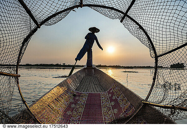 Myanmar  Shan state  Silhouette of traditional Intha fisherman on boat on Inle lake at sunset
