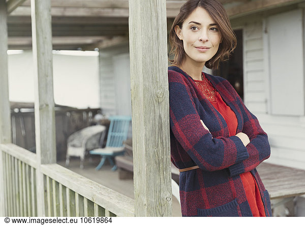 Nachdenkliche Frau im Pullover mit Blick auf die Veranda
