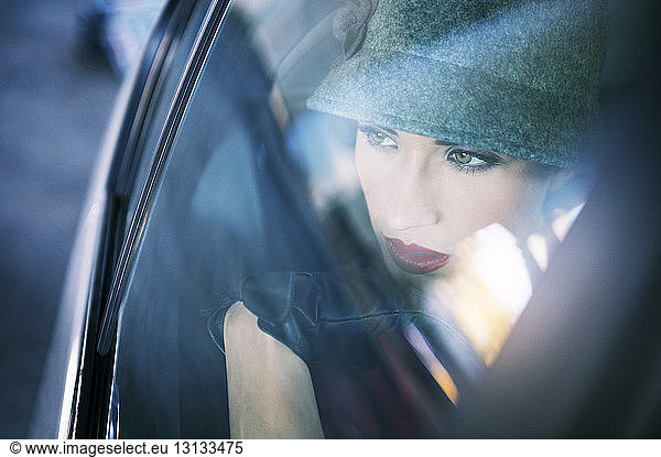 Nachdenkliche Frau schaut durch Autofenster