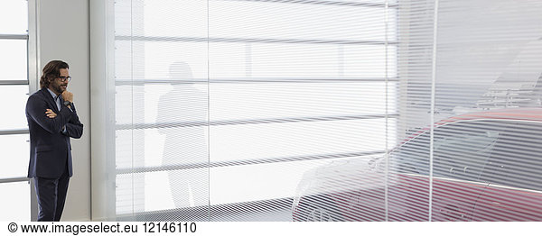 Nachdenklicher Autoverkäufer im Autohaus-Showroom