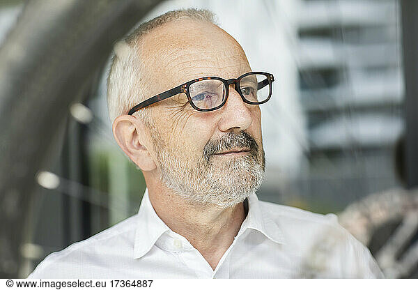 Nachdenklicher männlicher Berufstätiger mit Brille