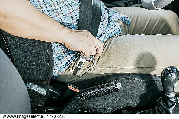 Nahaufnahme der Hände einer Person beim Anlegen des Sicherheitsgurts. Nahaufnahme der Hände des Fahrers beim Anlegen des Sicherheitsgurts  Hände des Fahrers beim Anlegen des Sicherheitsgurts. Sicherheitsgurt zur Unfallverhütung