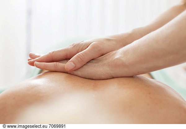 Nahaufnahme der menschlichen Hand bei einer Rückenmassage im Beauty Spa