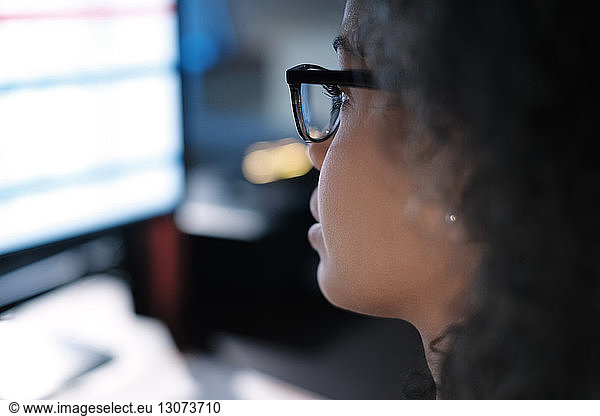 Nahaufnahme einer Geschäftsfrau mit Brille beim Blick auf den Computer im Büro