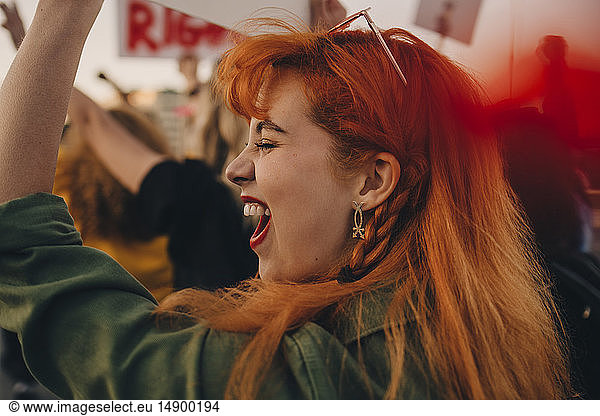 Nahaufnahme einer jungen Frau  die schreit  während sie für Rechte protestiert