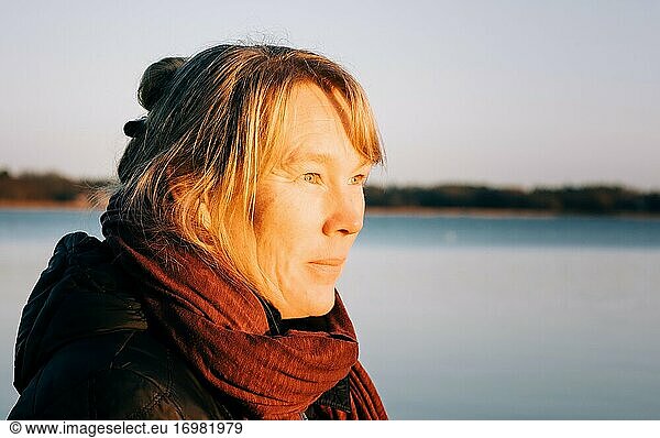 Nahaufnahme einer schwedischen Dame mit Blick auf das Meer bei Sonnenuntergang