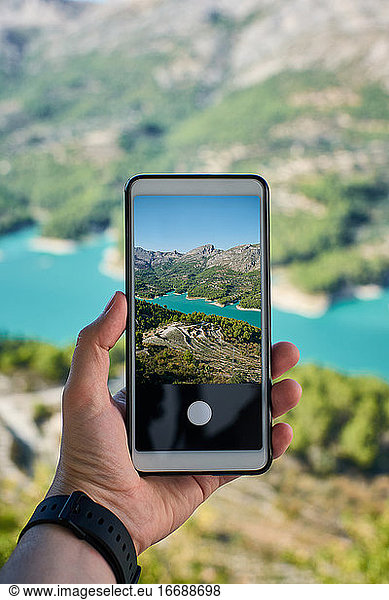 Nahaufnahme eines Handys mit einem Foto eines Sees