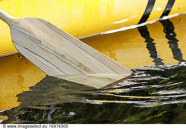 Nahaufnahme eines Kanu-Paddels  das in einen ruhigen  abgelegenen See eintaucht
