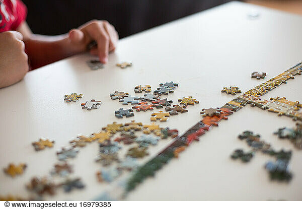 Nahaufnahme eines Kindes beim Zusammensetzen eines Puzzles