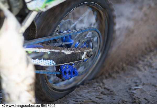 Nahaufnahme eines Motocross-Motorrads  das sich im Schlamm dreht