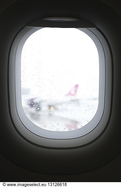 Nahaufnahme eines nassen Flugzeugfensters