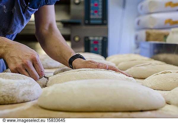 Nahaufnahme eines professionellen Bäckers bei der Zubereitung von Brotteig in einer Küche