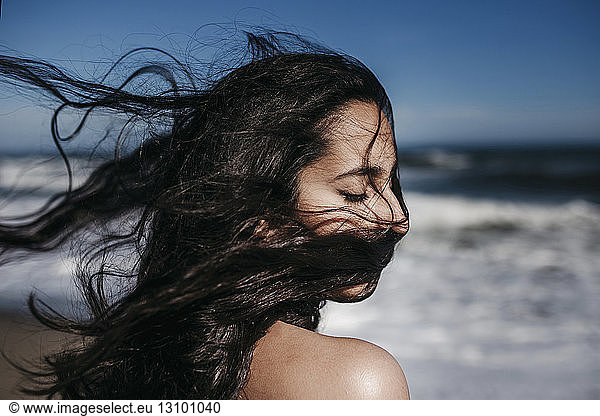 Nahaufnahme eines Teenager-Mädchens mit zerzaustem Haar am Strand