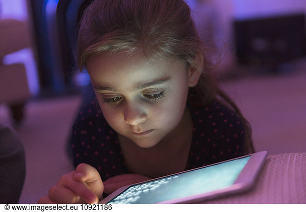 Nahaufnahme Mädchen spielen Spiel auf digitalem Tablett im Dunkeln