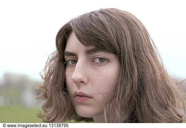 Nahaufnahme-Porträt einer seriösen jungen Frau mit braunen Haaren