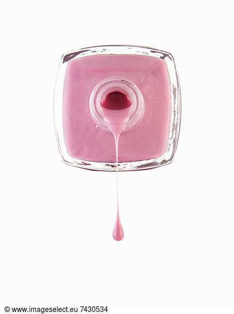 Nahaufnahme von rosa Fingernagelpolitur  die aus der Flasche tropft