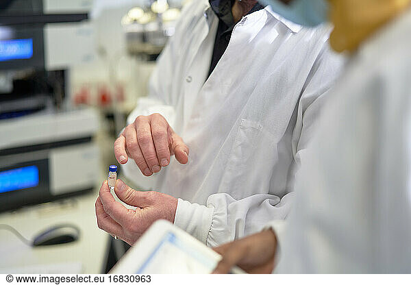 Nahaufnahme Wissenschaftler untersuchen Fläschchen im Labor