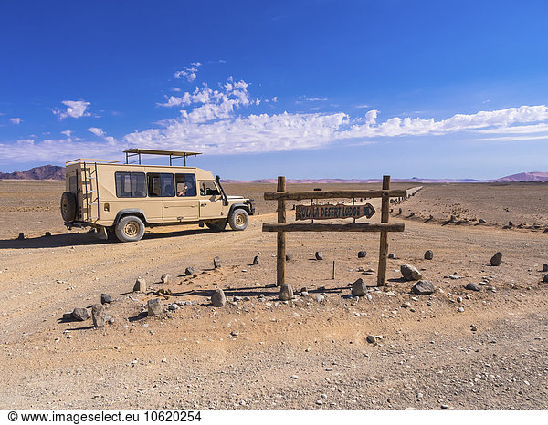 Namibia  Hardap  Fahrzeug auf Schotterstraße und Schild für eine Lodge